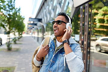 Image showing indian man in headphones with backpack in city