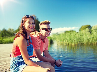 Image showing happy teenage couple sitting on river berth