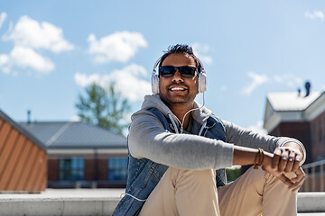 Image showing man in headphones listening to music on roof top