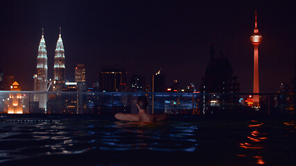 Image showing Looking at night Kuala Lumpur cityscape from rooftop pool, Malaysia