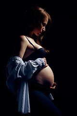 Image showing Profile of pregnant woman over black background