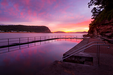 Image showing Red and pink dawn skies and reflections in the rock pool