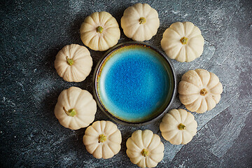 Image showing Cute white Baby boo mini pumpkins placed in circle with blue ceramic bowl in the middle