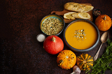 Image showing Homemade vegetarian pumpkin cream soup served in ceramic bowl. D