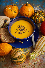 Image showing Compositon with autumn classic food. Tasty homemade pumpkin soup decorated with black seed