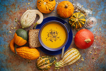 Image showing Compositon with autumn classic food. Tasty homemade pumpkin soup decorated with black seed