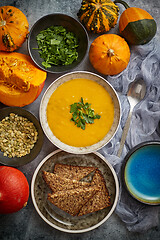 Image showing Pumpkin soup decorated with parsley for Thanksgiving, halloween. Placed on grey stone background