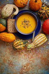 Image showing Compositon with autumn classic food. Tasty homemade pumpkin soup decorated with black seed