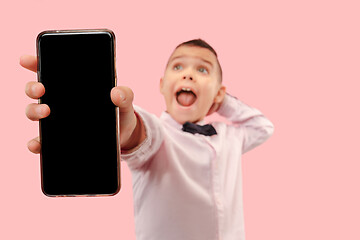 Image showing Indoor portrait of attractive young boy holding blank smartphone