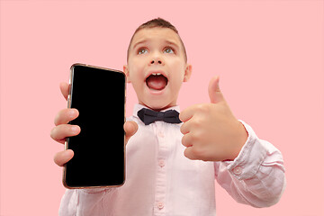 Image showing Indoor portrait of attractive young boy holding blank smartphone