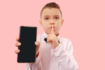 Image showing Indoor portrait of attractive young boy holding blank smartphone