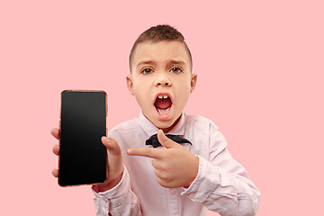 Image showing Indoor portrait of attractive young boy holding blank smartphone