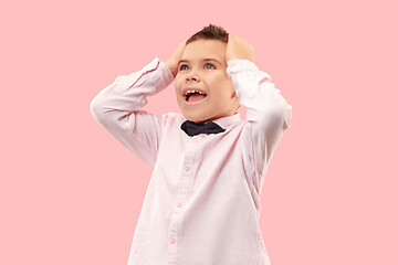 Image showing The young attractive teen boy looking suprised isolated on pink