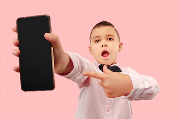 Image showing Indoor portrait of attractive young boy holding blank smartphone