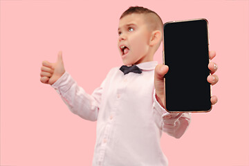 Image showing Indoor portrait of attractive young boy holding blank smartphone