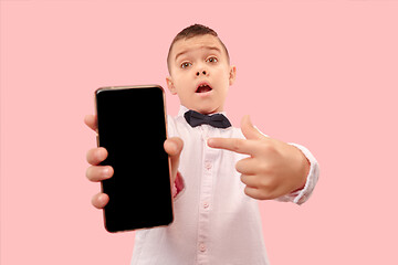 Image showing Indoor portrait of attractive young boy holding blank smartphone