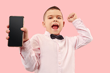 Image showing Indoor portrait of attractive young boy holding blank smartphone