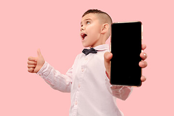 Image showing Indoor portrait of attractive young boy holding blank smartphone