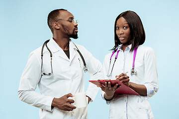 Image showing The female and male f happy afro american doctors on blue background