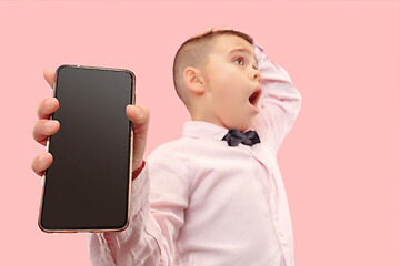 Image showing Indoor portrait of attractive young boy holding blank smartphone