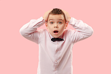 Image showing The young attractive teen boy looking suprised isolated on pink