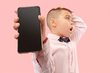 Image showing Indoor portrait of attractive young boy holding blank smartphone