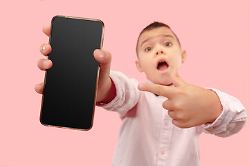 Image showing Indoor portrait of attractive young boy holding blank smartphone