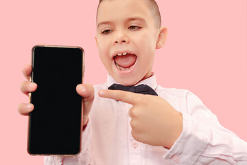 Image showing Indoor portrait of attractive young boy holding blank smartphone