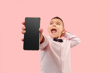 Image showing Indoor portrait of attractive young boy holding blank smartphone