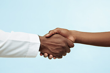 Image showing The female and male hands of afro american doctors on blue background