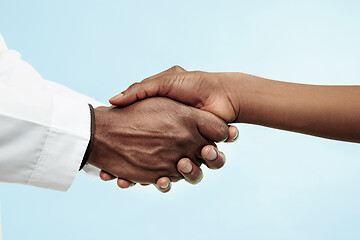 Image showing The female and male hands of afro american doctors on blue background