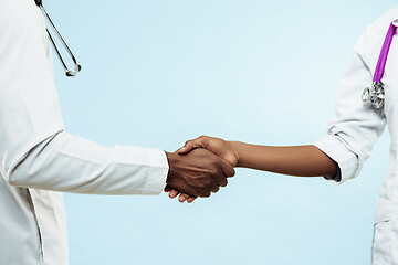 Image showing The female and male hands of afro american doctors on blue background