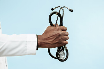 Image showing The male hand of afro american doctor on blue background