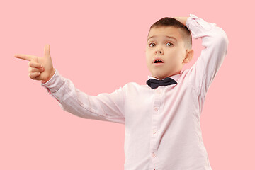 Image showing The young attractive teen boy looking suprised isolated on pink