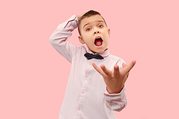 Image showing The young attractive teen boy looking suprised isolated on pink