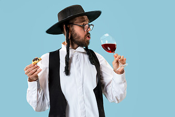 Image showing The young orthodox Jewish man with black hat with Hamantaschen cookies for Jewish festival of Purim