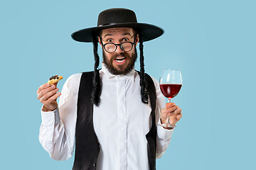 Image showing The young orthodox Jewish man with black hat with Hamantaschen cookies for Jewish festival of Purim