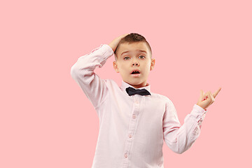 Image showing The young attractive teen boy looking suprised isolated on pink