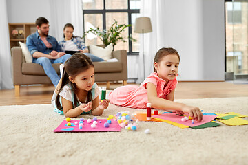 Image showing happy sisters doing arts and crafts at home