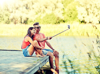 Image showing happy teenage couple taking selfie on smartphone