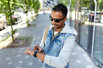 Image showing indian man with smart watch and backpack in city