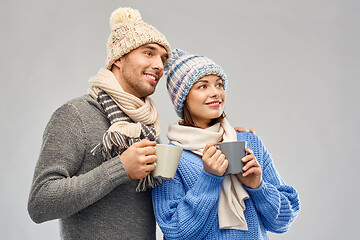 Image showing happy couple in winter clothes with mugs