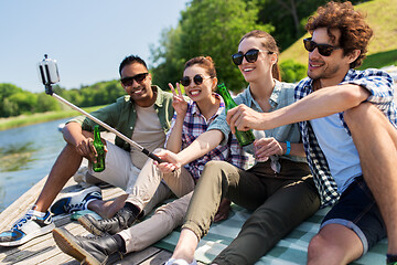 Image showing friends with drinks taking selfie on lake pier