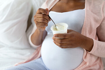 Image showing pregnant woman eating yogurt for breakfast in bed