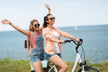 Image showing teenage girls or friends riding bicycle in summer