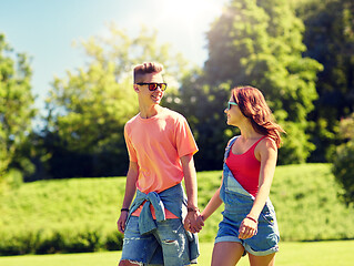 Image showing happy teenage couple walking at summer park