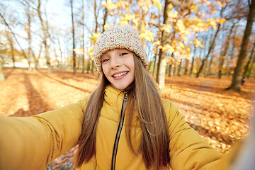 Image showing happy girl taking selfie at autumn park