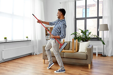 Image showing man with broom cleaning and having fun at home