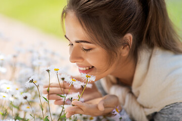 Image showing close up of woman smelling chamomile flowers