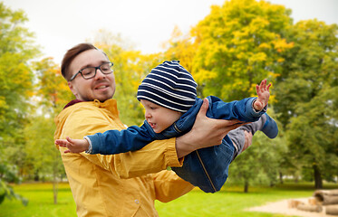 Image showing father with son playing and having fun in autumn